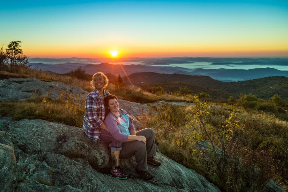 Couple watching sunset on mountaintop Couple watching sunset on mountaintop