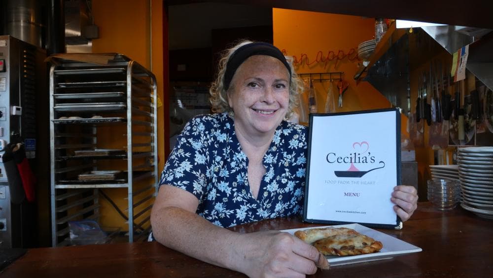 Cecilia Marchesini holds restaurant menu and plate of food Cecilia Marchesini holds restaurant menu and plate of food