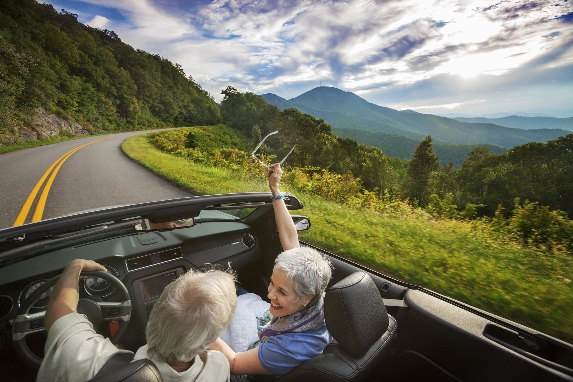 Couple in convertible on road in Asheville Couple in convertible on road in Asheville