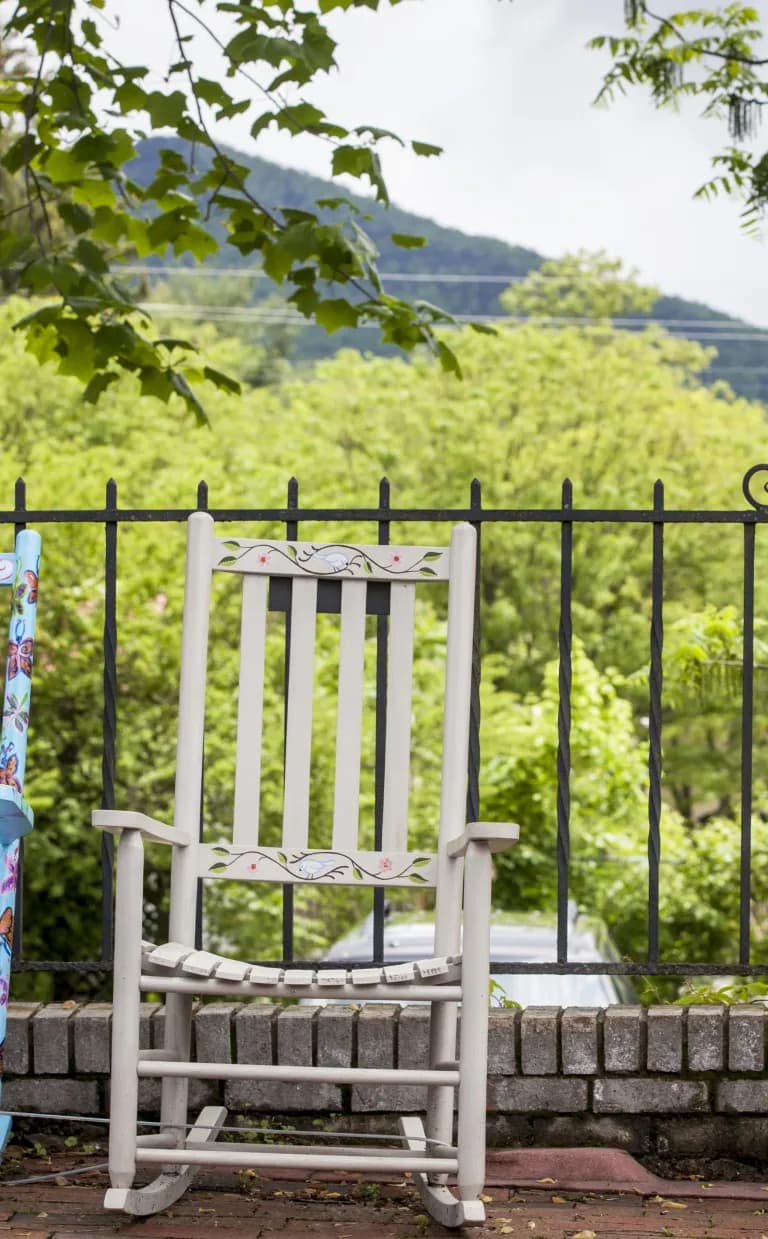Black Mountain: Small Town, Big Flavor two rocking chairs are on a deck in front of a stunning green mountain view